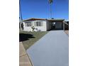 Single story home with a driveway, carport and desert landscaping at 4065 E University Dr # 83, Mesa, AZ 85205