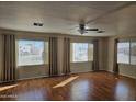 Bright living room featuring hardwood floors, ceiling fan and large windows at 4065 E University Dr # 83, Mesa, AZ 85205