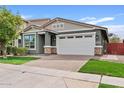 Charming single-Gathering home with a well-manicured lawn, a two-car garage, and attractive stone accents on the facade at 4197 E Rawhide St, Gilbert, AZ 85296