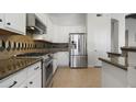 Modern kitchen featuring stainless steel appliances, granite countertops, and white cabinetry for a sleek and functional design at 4235 W Harrison St, Chandler, AZ 85226
