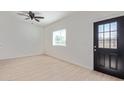 Bright living room features a black door with window, natural light, and wood-look floors at 463 W Taylor Ave, Coolidge, AZ 85128