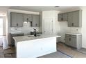 Modern kitchen featuring grey cabinets, a kitchen island, and stylish backsplash at 5628 W Summerside Rd, Laveen, AZ 85339