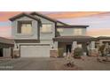 Charming two-story home featuring a two-car garage, desert landscaping, and a welcoming front porch at 7038 W Beverly Rd, Laveen, AZ 85339
