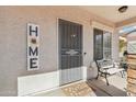 Welcoming front porch with secure front door, decorative sign, and charming bench seating at 7038 W Beverly Rd, Laveen, AZ 85339