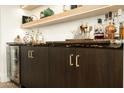 The bar area features open wood shelving with custom cabinetry and a beverage cooler at 7175 E Camelback Rd # 401, Scottsdale, AZ 85251
