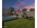Enjoy the outdoors in this yard featuring a private pool, green lawn, string lights, and seating at 7252 E Nido Ave, Mesa, AZ 85209