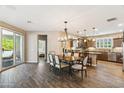 Bright dining room with wood floors, pendant lighting, and a view into the modern kitchen at 12734 W Crestvale Dr, Peoria, AZ 85383