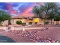 Inviting single-story home featuring desert landscaping, stone accents, and lush landscaping at 13007 W Tuckey Ct, Glendale, AZ 85307