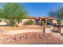 Inviting single-story home featuring desert landscaping, stone accents, and lush landscaping at 13007 W Tuckey Ct, Glendale, AZ 85307