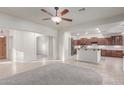 Open-concept living room with tile flooring, neutral walls, and views of the kitchen and entryway at 13007 W Tuckey Ct, Glendale, AZ 85307