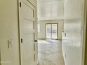 Bright hallway featuring tile floors that lead out to a sliding glass door at 1492 S 218Th Ln, Buckeye, AZ 85326