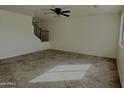 Spacious living room featuring neutral tile flooring and a ceiling fan at 1492 S 218Th Ln, Buckeye, AZ 85326