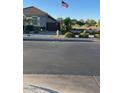 Street view of gray single-story home with US flag flying overhead at 21696 E Arroyo Verde Dr, Queen Creek, AZ 85142