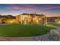 Beautifully landscaped front yard with lush green grass, desert plants and a circular driveway leading to the main entrance at 3616 E Kachina Dr, Phoenix, AZ 85044