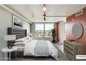 Bright bedroom with a tufted headboard, bedside tables and ample natural light from a large window with a view at 535 W Thomas Rd # 410, Phoenix, AZ 85013