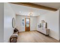 Inviting foyer with a wood door, light wood flooring, and stylish decor at 542 E Hayward Ave, Phoenix, AZ 85020