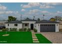 Well-manicured front yard with a modern exterior, a paved driveway, and a two-car garage at 6719 N 10Th Pl, Phoenix, AZ 85014