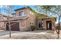 Two story home with a large two car garage, rock accents, and a well manicured front yard at 9545 W Williams St, Tolleson, AZ 85353