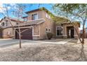 Two story home with a large two car garage, rock accents, and a well manicured front yard at 9545 W Williams St, Tolleson, AZ 85353