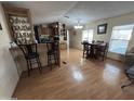 Open-concept space with bar stool seating, a dining table and wood-look floors throughout the kitchen and living room at 9828 E Pueblo Ave # 67, Mesa, AZ 85208