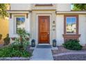 Inviting front entrance with a solid wood door, stylish lanterns, manicured landscaping, and clear address display at 10219 E Isleta Ave, Mesa, AZ 85209