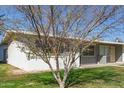 Well-manicured lawn surrounds this single-story home, complemented by mature trees at 10392 W Deanne Dr, Sun City, AZ 85351