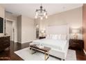 Bright bedroom featuring a plush bed, wood floors, and ensuite bathroom access at 12129 W Desert Mirage Dr, Peoria, AZ 85383