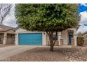 Well-kept single-story home features a blue garage door, stone detail, and xeriscaped front yard at 1434 W Brangus Way, San Tan Valley, AZ 85143