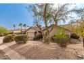 Inviting home with desert landscaping and mature trees creating a serene setting at 14402 N Silverado Dr, Fountain Hills, AZ 85268