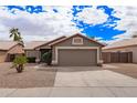 Traditional single-story home with a two-car garage, desert landscaping, and a paved driveway at 14609 W Marcus Dr, Surprise, AZ 85374