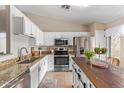 Bright kitchen with stainless appliances, white cabinets, granite countertops, and a butcher block island at 14609 W Marcus Dr, Surprise, AZ 85374