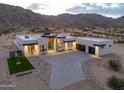 Desert modern home showcasing stylish exterior and landscape lighting at 15574 N Brielles Way, Maricopa, AZ 85139