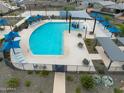 Aerial view of a community pool surrounded by lounge chairs, umbrellas, and tables at 16013 W Desert Hollow Dr, Surprise, AZ 85387