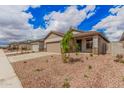 Street view of single Gathering homes with drought resistant landscaping and attached garages at 16972 W Fetlock Trl, Surprise, AZ 85387