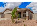 Close-up showcasing the front of the house with a teal door and desert landscaping at 16972 W Fetlock Trl, Surprise, AZ 85387