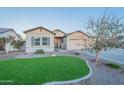 Inviting single-story home with well-maintained synthetic grass, desert landscaping, and a spacious three-car garage at 21397 S 215Th Way, Queen Creek, AZ 85142