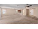 Spacious living room with neutral-toned carpet, a ceiling fan, and views into the kitchen area at 2142 E Wildhorse Dr, Chandler, AZ 85286