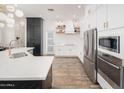 Modern kitchen with white cabinets, stainless steel appliances, subway tile backsplash, and dark countertops at 23420 S 202Nd St, Queen Creek, AZ 85142