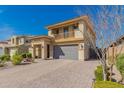 Inviting two-story home with a balcony, showcasing a neutral stucco exterior, paver driveway, and drought-tolerant landscaping at 2748 E Cherry Hill Dr, Gilbert, AZ 85298