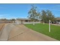 Quaint single-story house showcasing its inviting front yard and extended driveway at 3333 N 81St Ave, Phoenix, AZ 85033