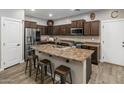 Well-equipped kitchen featuring granite counters, wooden cabinets, stainless steel appliances, and breakfast bar at 3518 S Posse Trl, Gilbert, AZ 85297