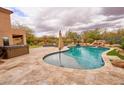 Outdoor oasis featuring a sparkling pool, relaxing hot tub, and lush landscaping for ultimate backyard enjoyment at 4365 E Milton Dr, Cave Creek, AZ 85331