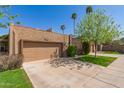 Quaint single-story home featuring a two-car garage, landscaped front yard, and mature shade trees at 5513 N 5Th Dr, Phoenix, AZ 85013