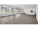 Bright, open-concept living space with wood-look tile flooring, white walls, and a view of the desert landscape at 6107 E Lone Mountain Rd, Cave Creek, AZ 85331