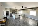 Open-concept kitchen and living area with stainless steel appliances, island seating, and stylish gray flooring at 6107 E Lone Mountain Rd, Cave Creek, AZ 85331