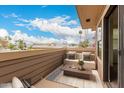 A cozy outdoor patio with cushioned seating, a table, and a view of palm trees at 702 S Beck Ave, Tempe, AZ 85281
