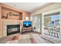 Cozy living room featuring a fireplace, balcony access, and neutral decor at 7401 W Arrowhead Clubhouse Dr # 2012, Glendale, AZ 85308