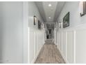 Hallway features wainscoting, wood-look tile, and modern lighting leading to the living area at 7518 E Vista Bonita Dr, Scottsdale, AZ 85255