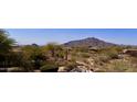 Resort style pool with a rock waterfall feature overlooking a scenic mountain view at 8386 E Arroyo Seco Rd, Scottsdale, AZ 85266