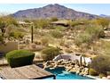 Resort style pool with a rock waterfall feature overlooking a scenic mountain view at 8386 E Arroyo Seco Rd, Scottsdale, AZ 85266